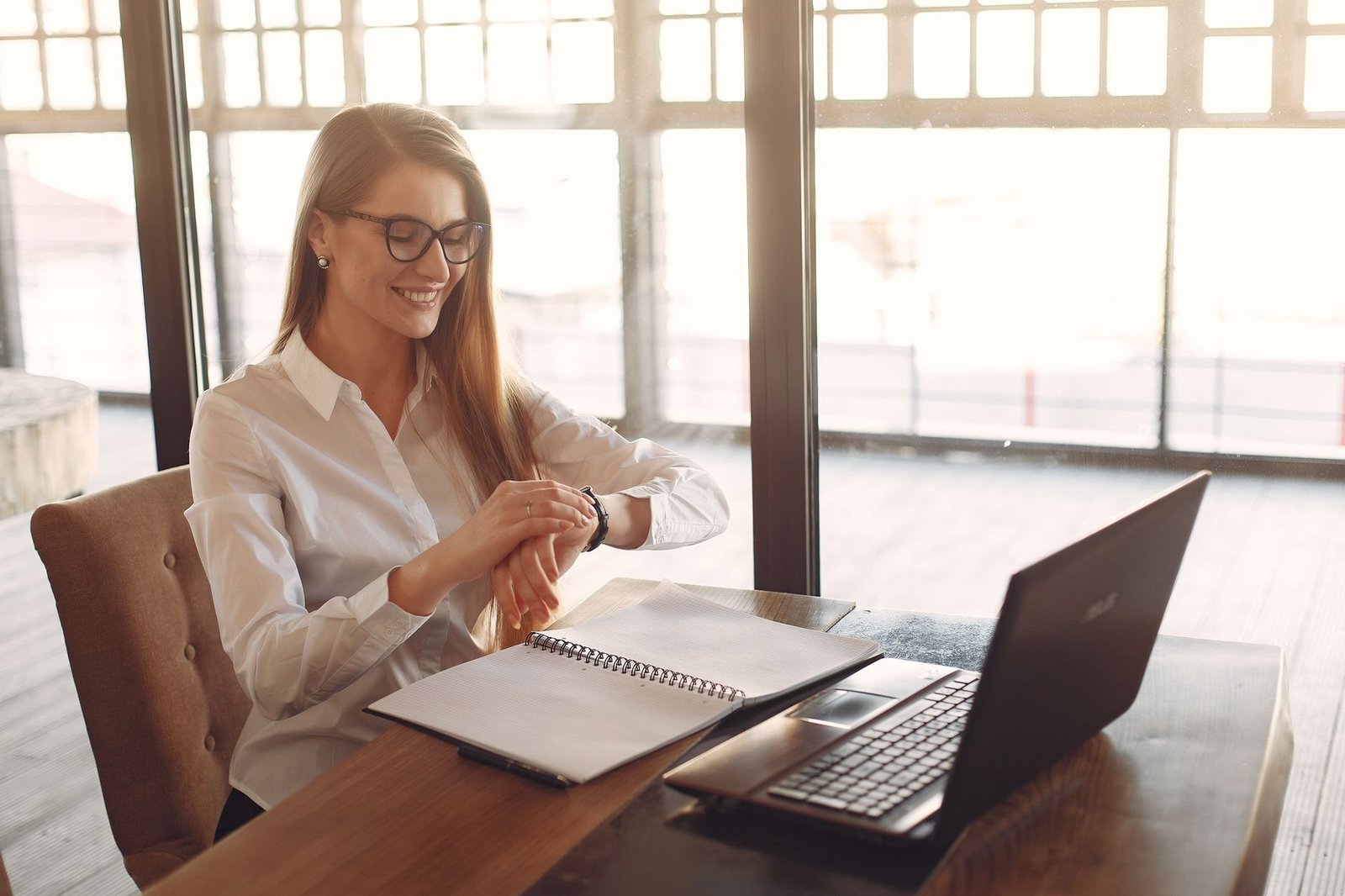 Confident young businesswoman smiling in a bright, sunlit workspace