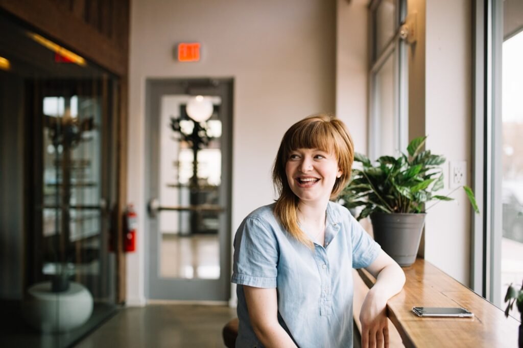 Smiling woman relaxed and relieved in an office with natural daylight