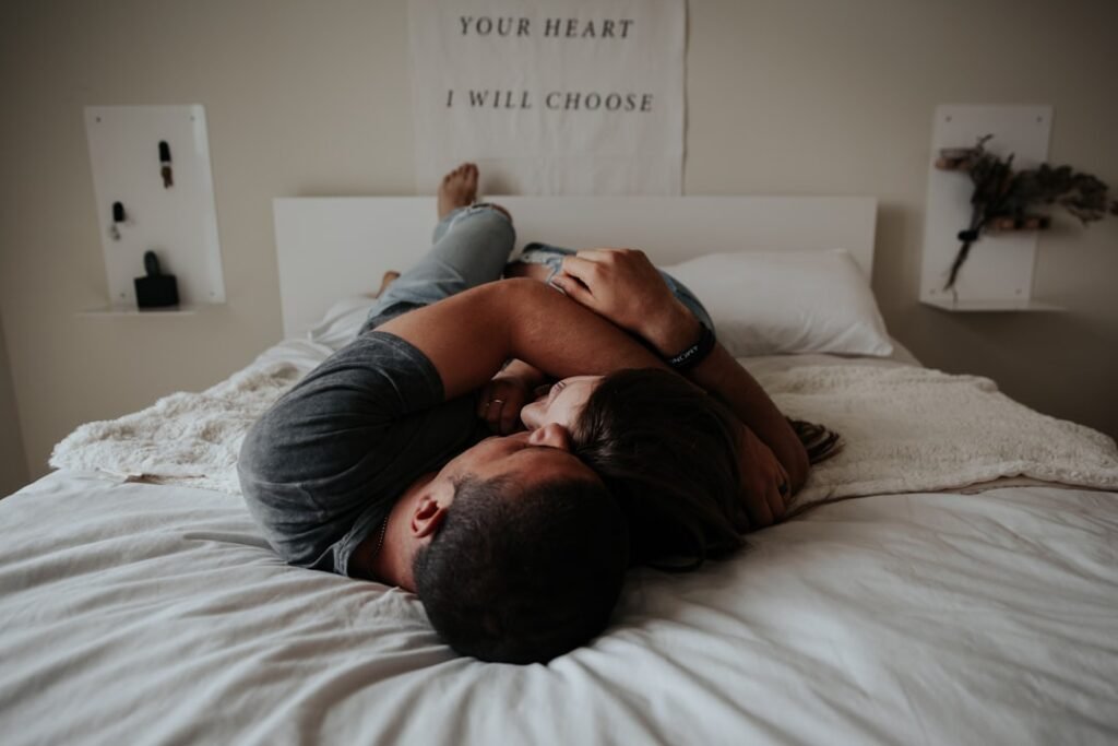 Couple relaxing together in bedroom with morning sunlight
