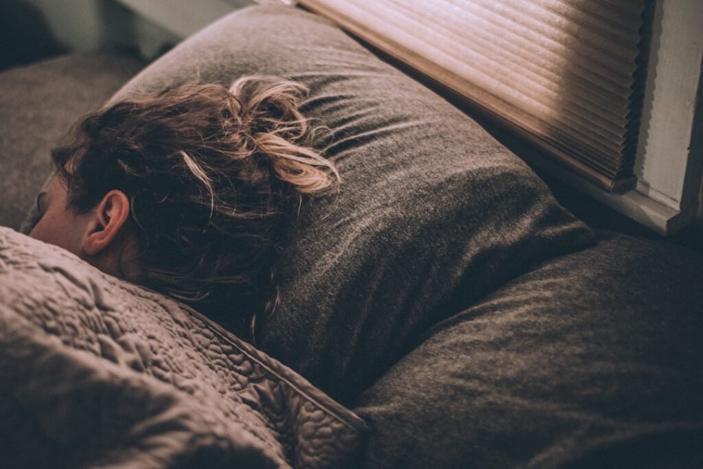 Woman sleeping peacefully in bed with morning daylight
