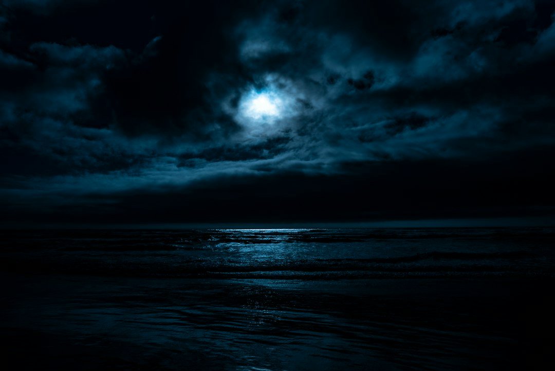 Full moon reflecting over calm water at night