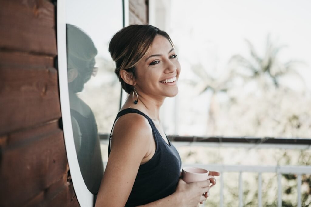 Smiling relieved woman in front of a sunlit window