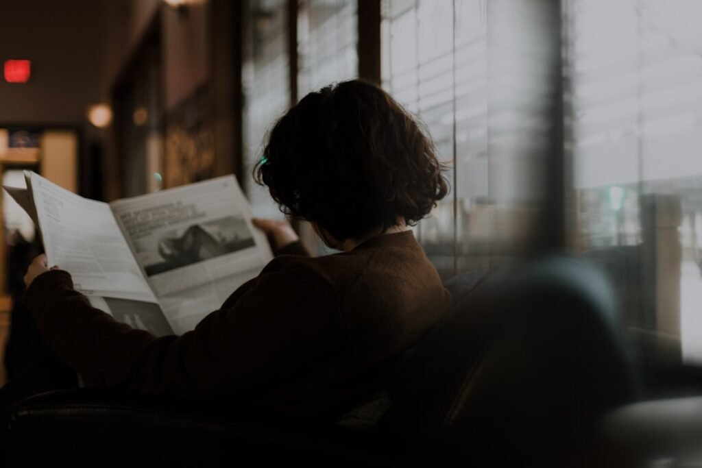 Woman reading a document by a sunlit window