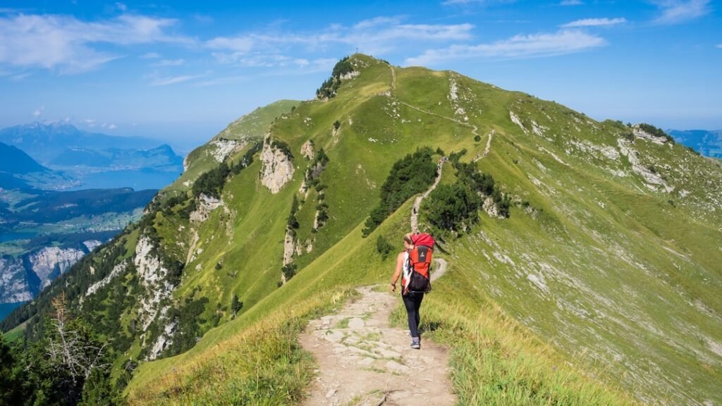 Person hiking a mountain path on a long journey in daylight