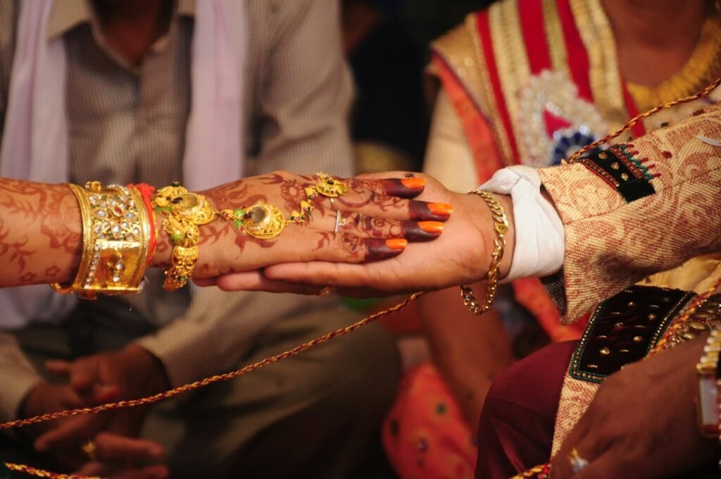 Bride and groom's hands during an Indian wedding ritual, representing Mangal Dosha remedies