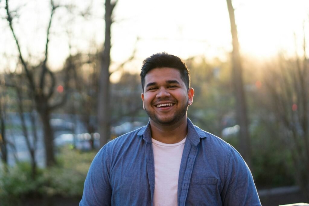 Confident young man smiling outdoors in daylight