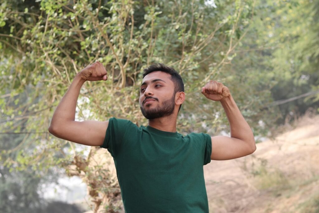 Man celebrating a milestone with arms raised in daylight