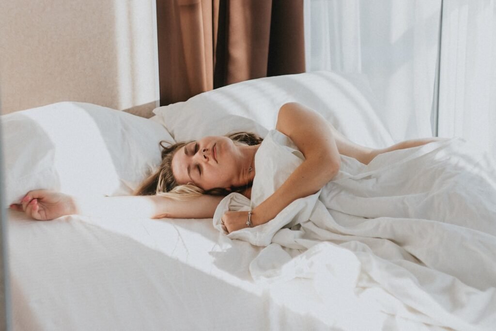 Person resting peacefully in bed near a daylight window