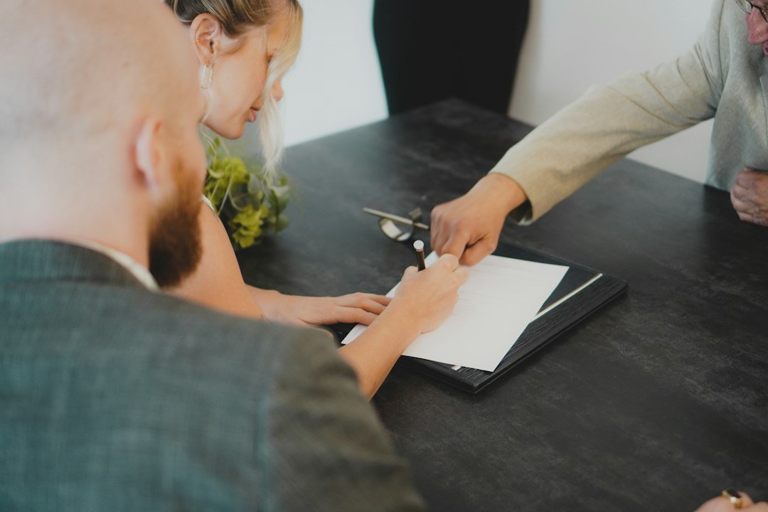 Couple signing a contract together at a desk