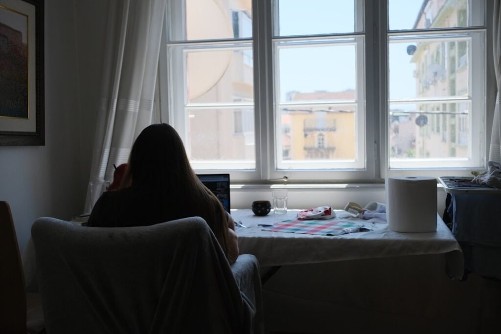 Person working near a bright daylight window at home