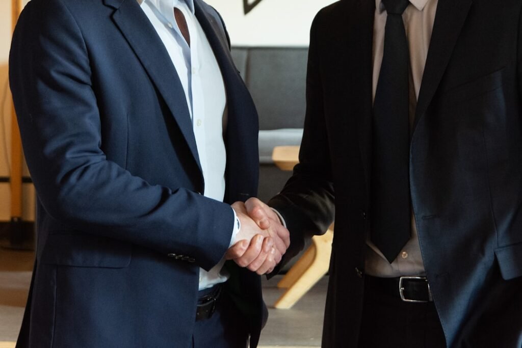 Two business partners shaking hands in agreement in an office