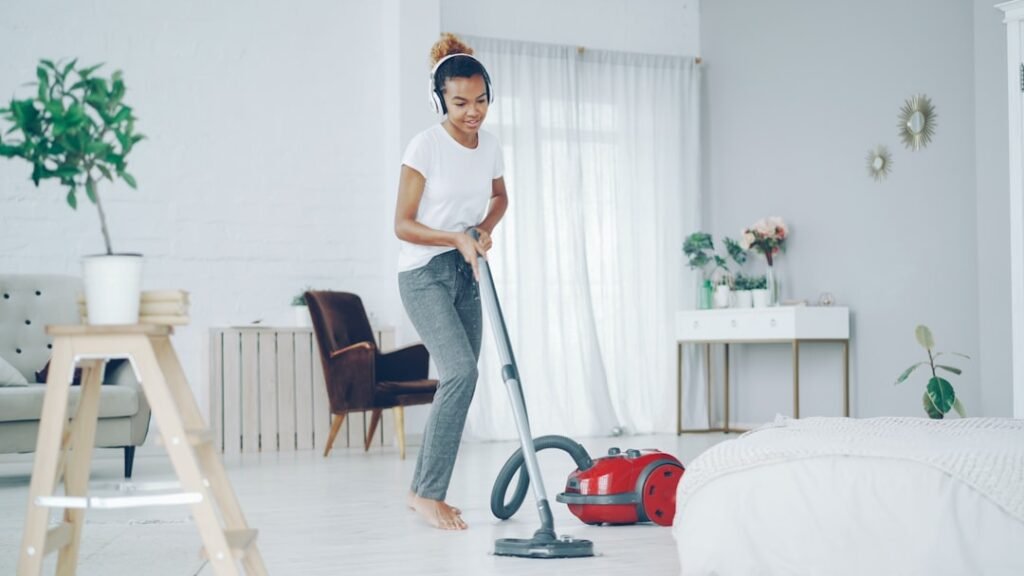 Cheerful woman tidying a bright room in daylight