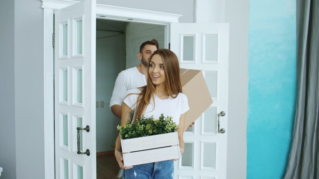 Young couple walking happily into their new home in daylight