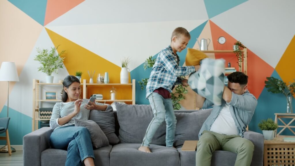 father son playing couch colorful home