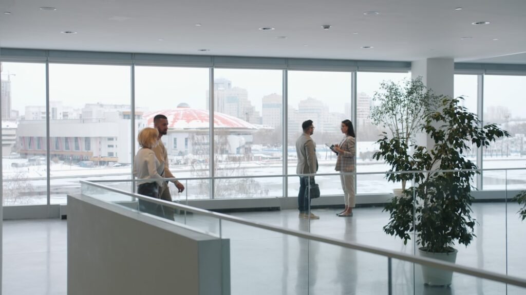 Man and woman business colleagues talking in office lobby, public professional standing