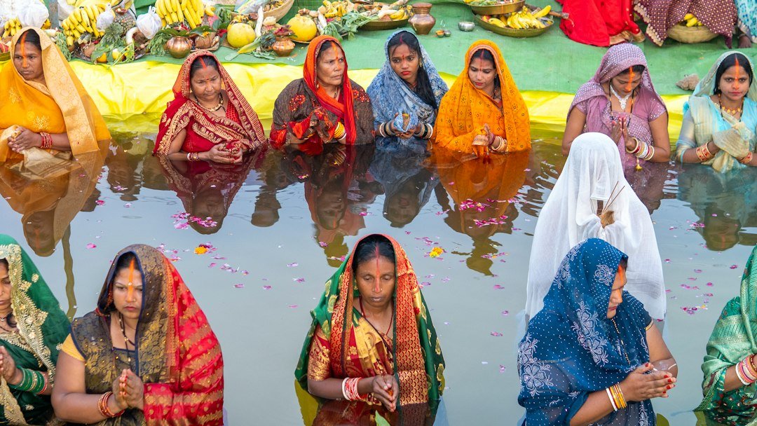 Devotees offering water to the rising Sun in a traditional Surya puja
