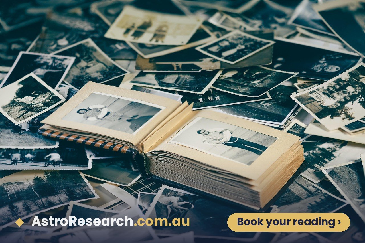 Couple looking through old family photographs together, the kind of family records that can help find an exact time of birth