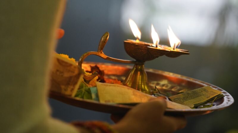 Ritual plate with lit diyas held for the Diwali Lakshmi puja aarti