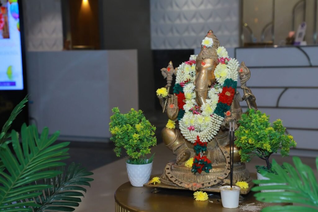 Golden Ganesha statue decorated with fresh flower garlands