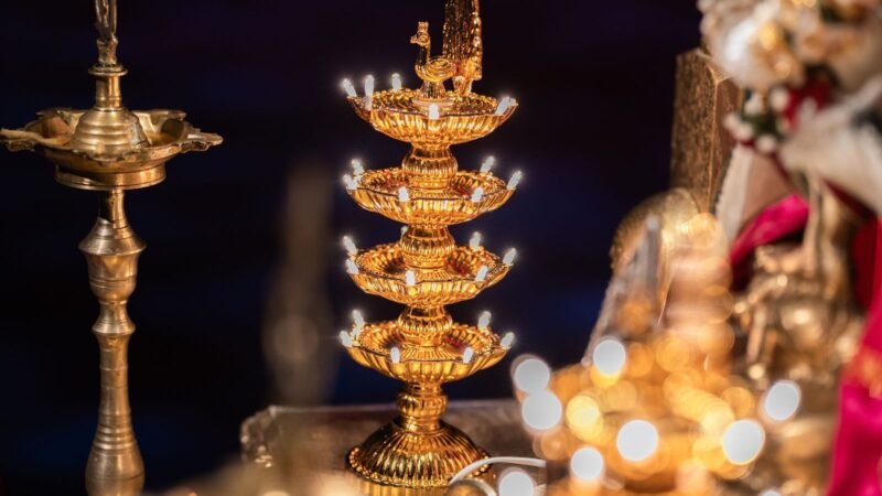 Polished brass oil lamps lit for the Dhanteras evening puja