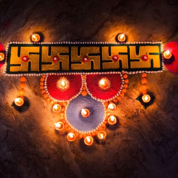 Colourful rangoli at an entrance with lit diyas for Choti Diwali
