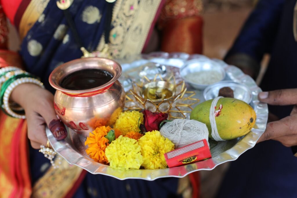 Puja thali with flowers, mango leaves and a copper kalash