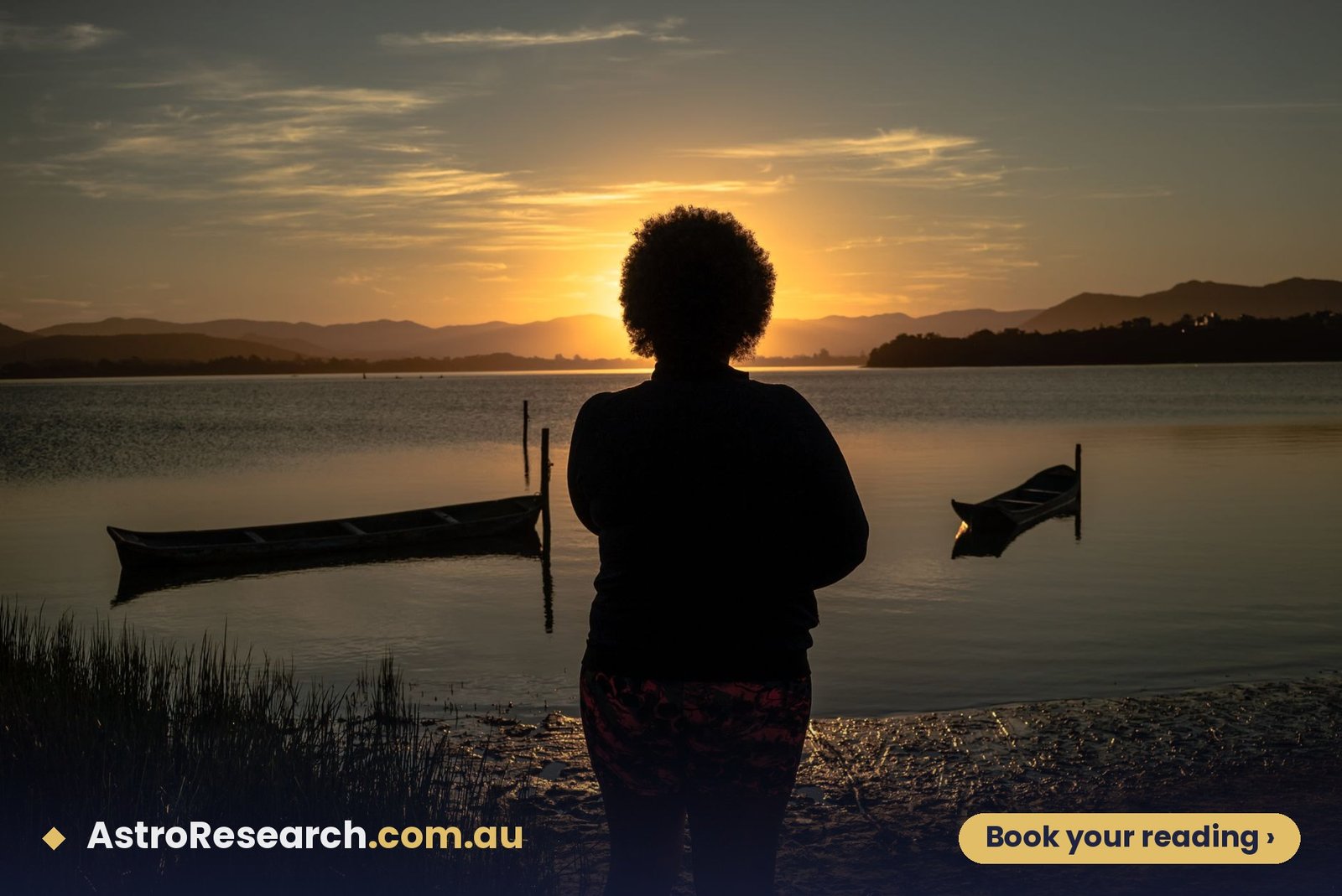 Woman standing by a calm lake watching the sunrise over mountains, reflecting on Ketu Mahadasha