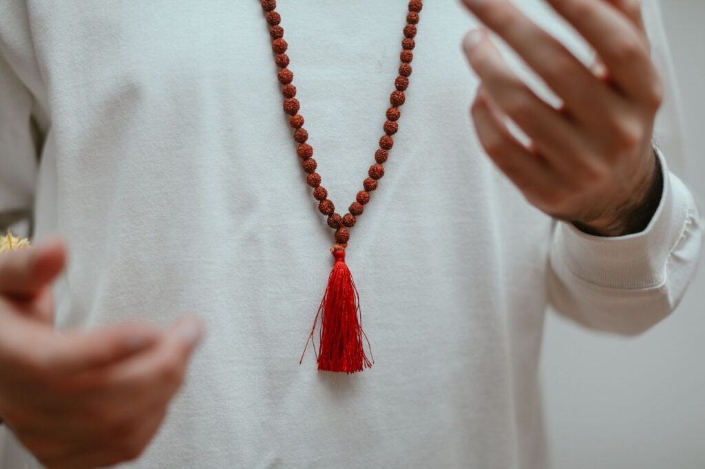 Hands holding a rudraksha mala for mantra chanting